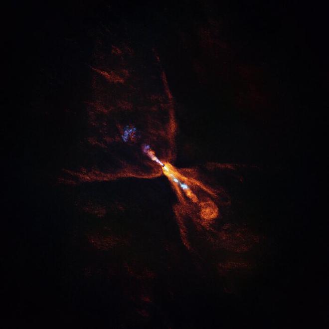 HOPS-315, una estrella bebé en la que un equipo de astrónomas y astrónomos detectó pruebas de las primeras etapas de la formación de planetas. La imagen fue tomada con el Atacama Large Millimeter/submillimeter Array (ALMA), del que ESO es socio. Junto con los datos del Telescopio Espacial James Webb (JWST), estas observaciones muestran que los minerales calientes están comenzando a solidificarse. En naranja vemos la distribución del monóxido de carbono, que se aleja de la estrella en un viento en forma de mariposa. En azul vemos un estrecho chorro de monóxido de silicio, que también se aleja de la estrella. Estos vientos y chorros gaseosos son comunes alrededor de estrellas bebé como HOPS-315. En conjunto, las observaciones de ALMA y JWST indican que, además de estas características, también hay un disco de monóxido de silicio gaseoso alrededor de la estrella que se está condensando en silicatos sólidos, las primeras etapas de la formación planetaria. Crédito: ALMA(ESO/NAOJ/NRAO)/M. McClure et al.