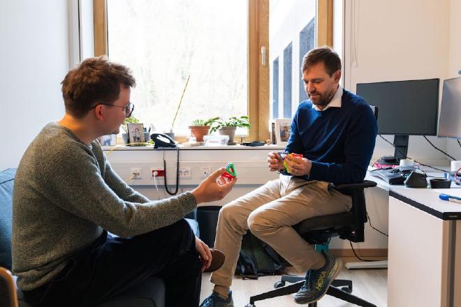 Físicos de la ISTA crearon un manual teórico sobre el autoensamblaje. El primer autor del estudio, el estudiante de doctorado Maximilian Hübl, y el profesor adjunto Carl Goodrich manipulan un modelo de juguete simplificado mientras discuten sus hallazgos. Crédito y sopyright de la imagen: ISTA