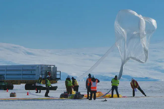 Miembros de la tripulación de tierra comienza a inflar un globo científico como preparación para el lanzamiento de la misión Carga Útil para Observaciones de Ultraalta Energía (PUEO) de la NASA. El globo despegó de la Antártida a las 5:56 a. m. NZST del sábado 20 de diciembre de 2025. Crédito de la imagen: NASA/Scott Battaion