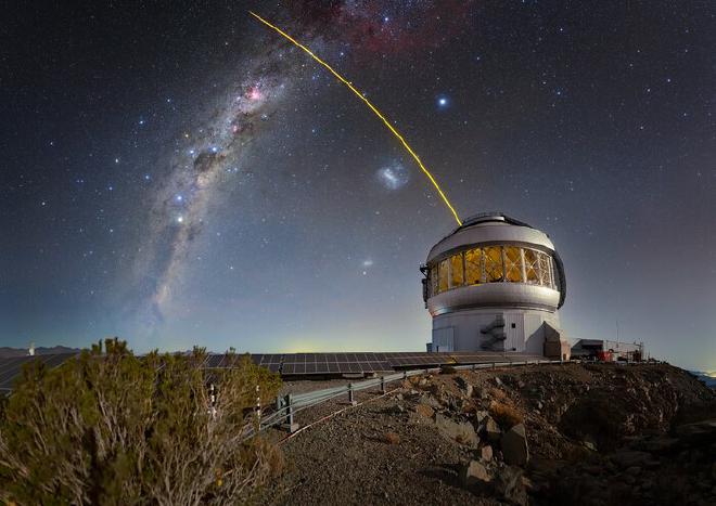 Gemini Sur, una de las dos mitades del Observatorio Internacional Gemini, un programa de NSF NOIRLab, se ve aquí con su estrella guía láser en acción. Ambos telescopios Gemini utilizan estrellas guía láser para obtener datos para la calibración de su óptica adaptativa, sistemas de espejos deformables que compensan las fluctuaciones en la atmósfera superior, que pueden desenfocar las imágenes de estrellas y galaxias distantes. El láser excita partículas de gas traza en la atmósfera superior de la Tierra. El software analiza la retroalimentación del láser para generar un modelo con el que la óptica adaptativa pueda mapear. Las estrellas guía láser también pueden complementarse con sistemas de óptica adaptativa adicionales que utilizan imágenes de estrellas reales del propio telescopio, como el Sensor de Estrella Guía Natural de Próxima Generación (NGS-2). Esta foto fue tomada como parte de la  expedición fotográfica NOIRLab 2022 a todos los sitios de NOIRLab. Crédito de la imagen: Observatorio Internacional Gemini/NOIRLab/NSF/AURA/T. Slovinský