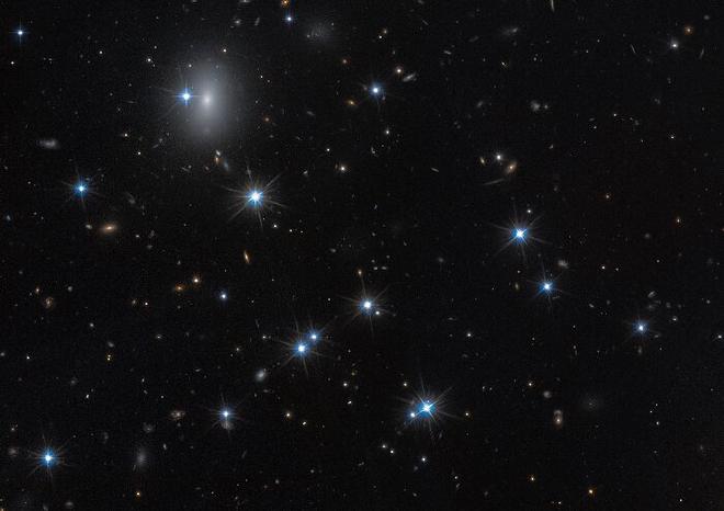 La galaxia CDG-2, de bajo brillo superficial, que se muestra en esta imagen captada por el Telescopio Espacial Hubble, está dominada por materia oscura y contiene sólo una escasa dispersión de estrellas. Esta galaxia es casi invisible, pero mediante el uso de técnicas estadísticas avanzadas, los científicos la identificaron buscando grupos apretados de estrellas llamados cúmulos globulares que se hallan en el centro de esta imagen. Las observaciones del Hubble incluyen las del 
    programa 15235 (W. Harris). Crédito de la imagen: NASA, ESA, D. Li (Utoronto), Procesamiento de imágenes: J. DePasquale (STScI)